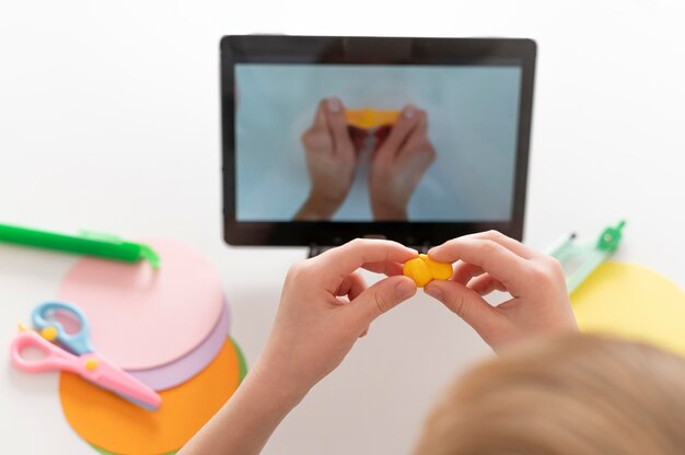 Little boy playing while looking at tablet