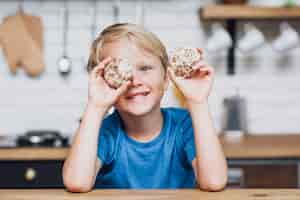 Free photo little boy playing with cookies