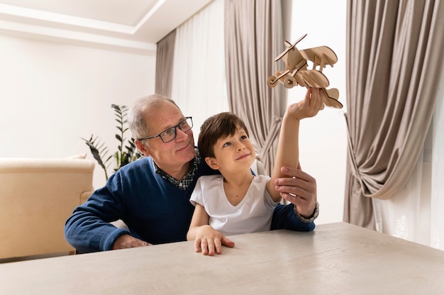 Free photo little boy playing with his grandfather