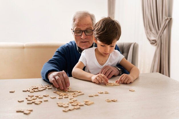 Маленький мальчик играет со своим дедом