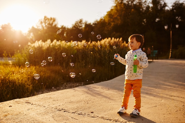 Free photo little boy playing with soap bubbles