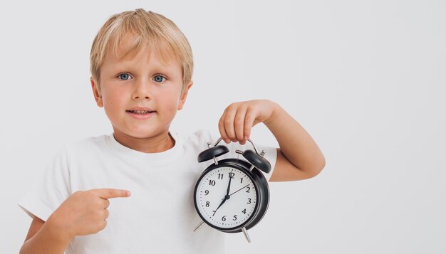 Little boy pointing at a clock