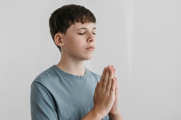 屋内で祈る少年