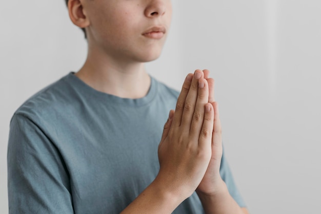 Free photo little boy praying with his hands