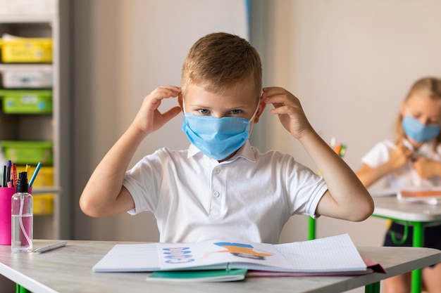 Little boy putting on his medical mask