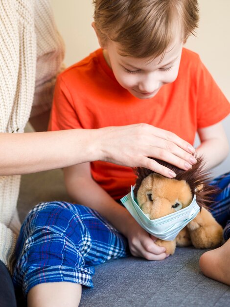 Little boy putting on toy mask