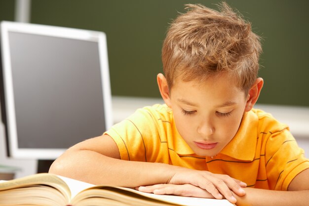 Little boy reading in class