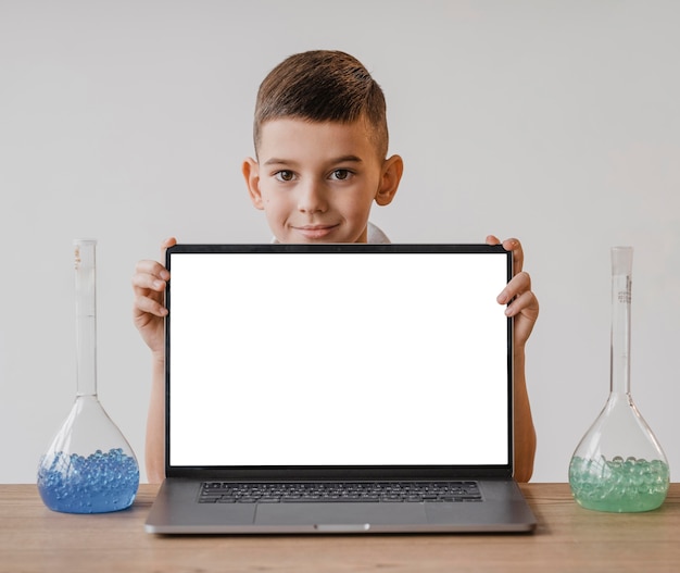 Free photo little boy showing a blank screen laptop