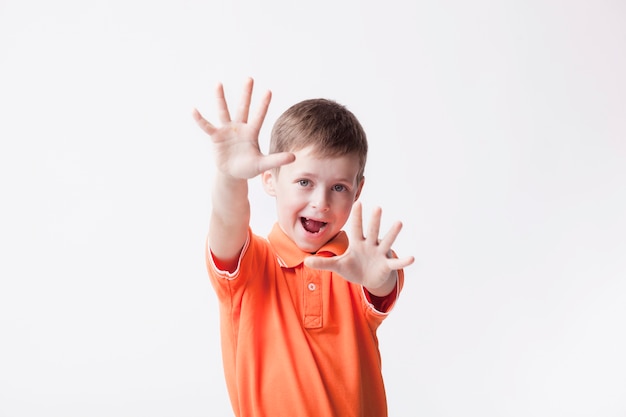 Маленький мальчик показывает стоп жест с открытым ртом на белом фоне