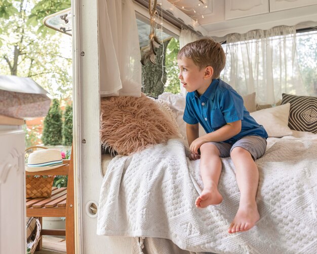 Little boy sitting on a bad in a caravan