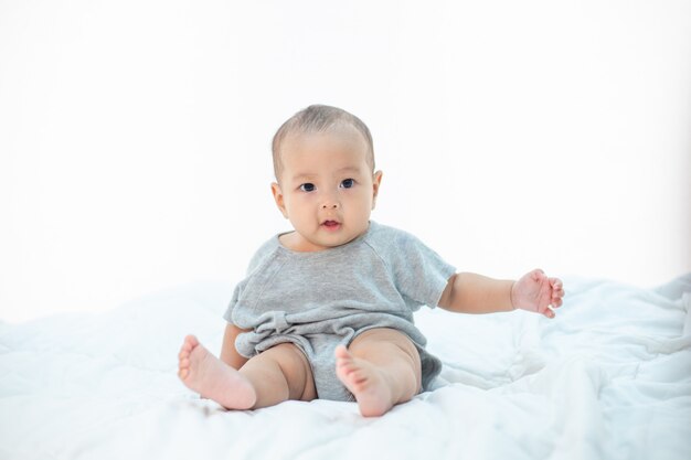 The little boy sitting on the bed