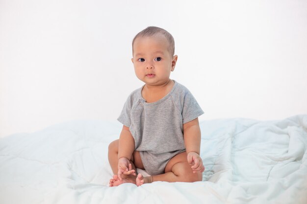 The little boy sitting on the bed