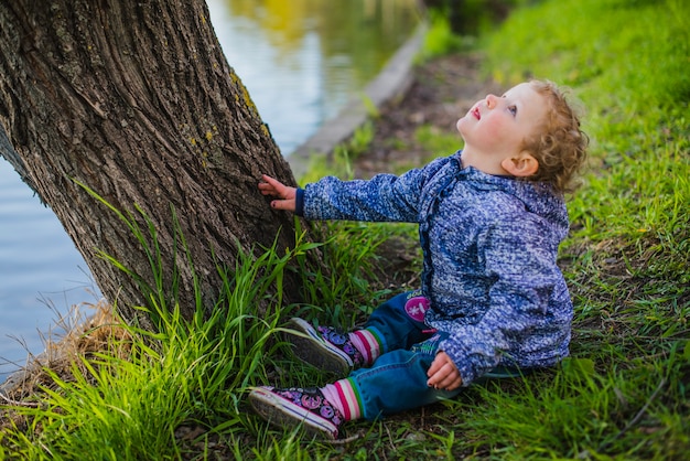 Little boy sitting on grass