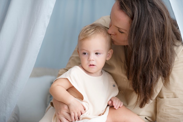 彼の母親の膝に座っている小さな男の子