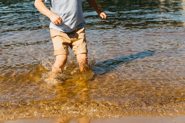 Foto gratuita ragazzino che spruzza in acqua