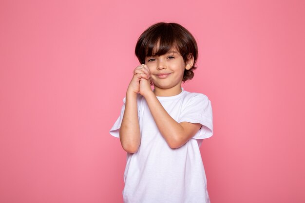 Little boy sweet cute adorable in white t-shirt on pink