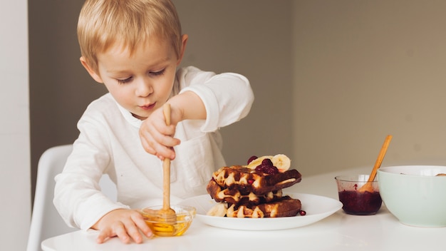 Little boy taking honey