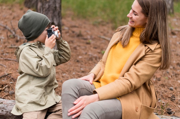 Little boy taking a photo of his mother