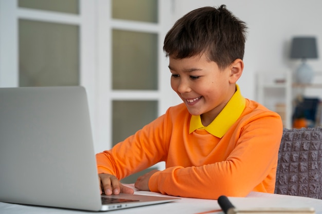 Free photo little boy watching films on laptop