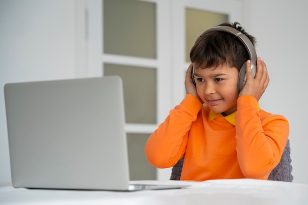 Free photo little boy watching films on laptop