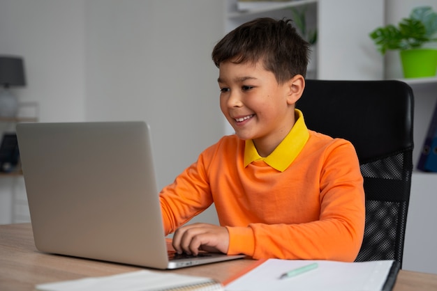 Free photo little boy watching films on laptop