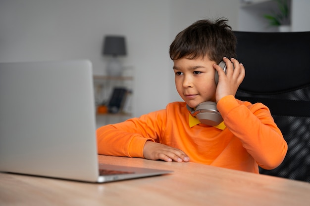 Free photo little boy watching films on laptop