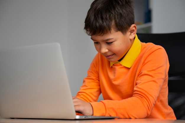 Free photo little boy watching films on laptop