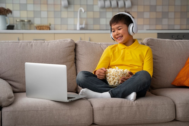 Free photo little boy watching films on laptop