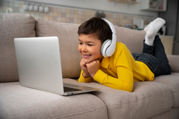 Free photo little boy watching films on laptop