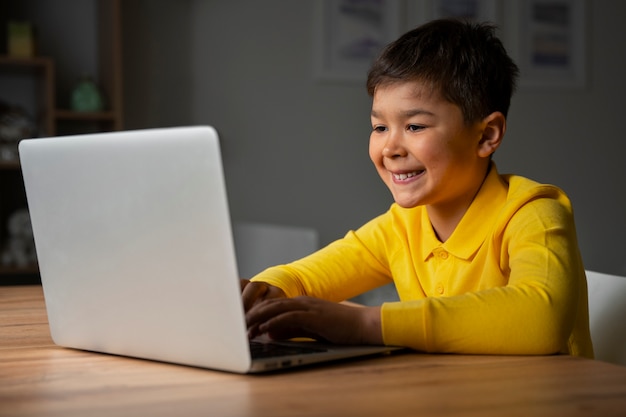 Free photo little boy watching films on laptop