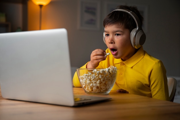 Free photo little boy watching films on laptop