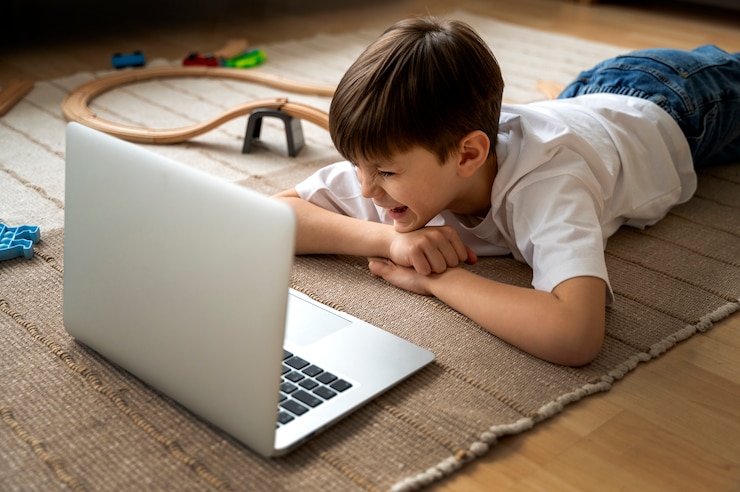 Free Photo little boy watching films on the laptop