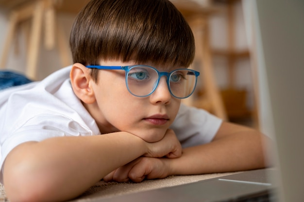 Free photo little boy watching films on the laptop