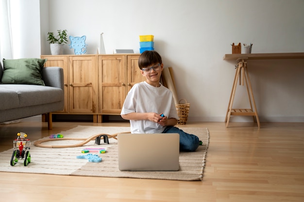 Free photo little boy watching films on the laptop