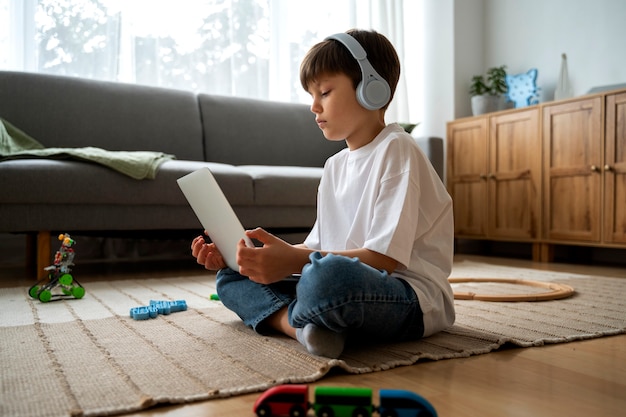 Free photo little boy watching films on the laptop