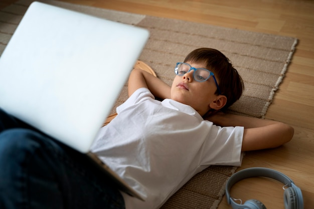 Free photo little boy watching films on the laptop