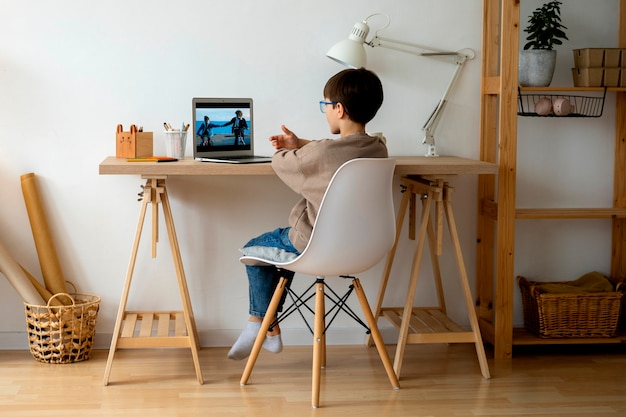 Free photo little boy watching films on the laptop