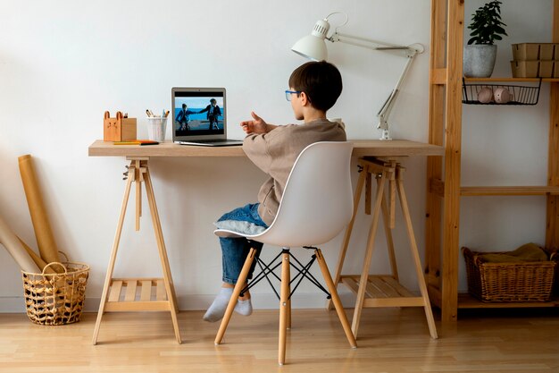 Free Photo little boy watching films on the laptop