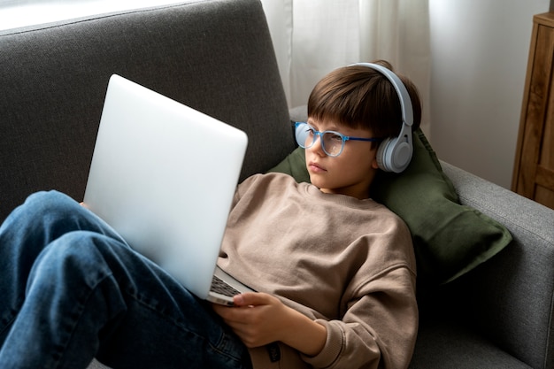 Free photo little boy watching films on the laptop