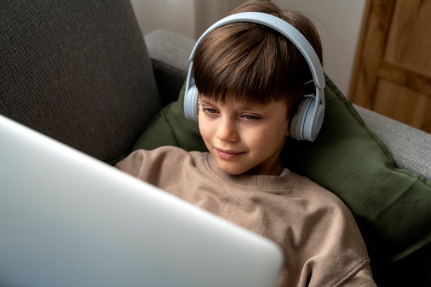 Free photo little boy watching films on the laptop