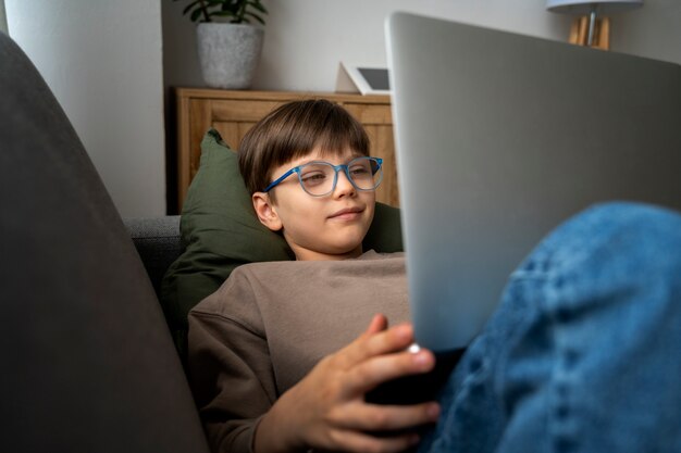 Free photo little boy watching films on the laptop