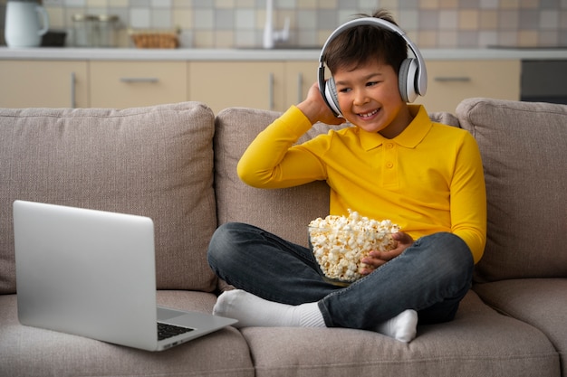 Бесплатное фото Маленький мальчик смотрит фильмы на ноутбуке