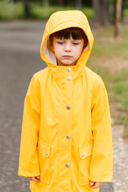 Little boy wearing yellow rain coat