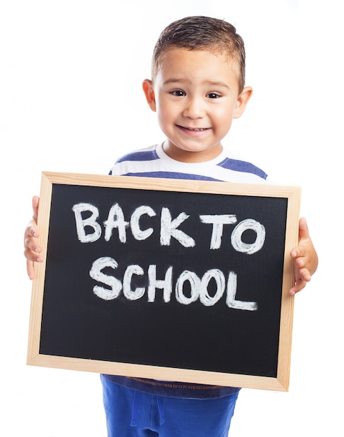 Little boy with a blackboard with the message "back to school"