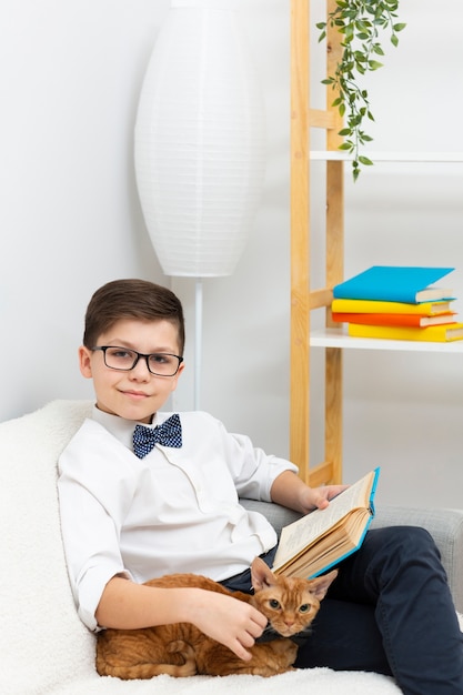 Free photo little boy with cat reading