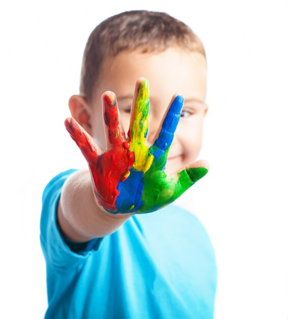 Little boy with a hand full of paint covering his face