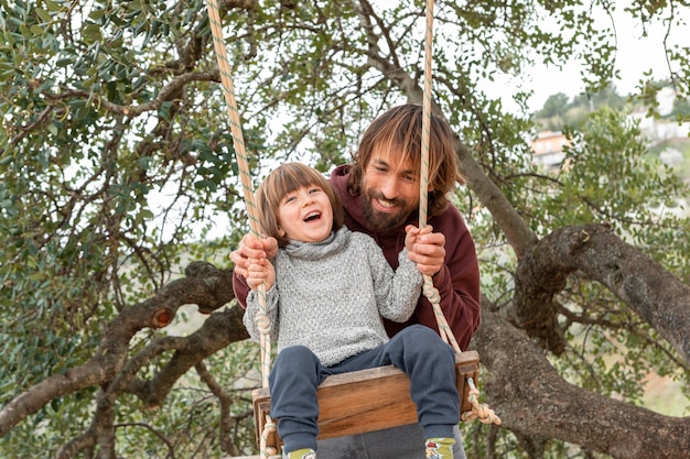 Foto gratuita ragazzino con suo padre che gioca