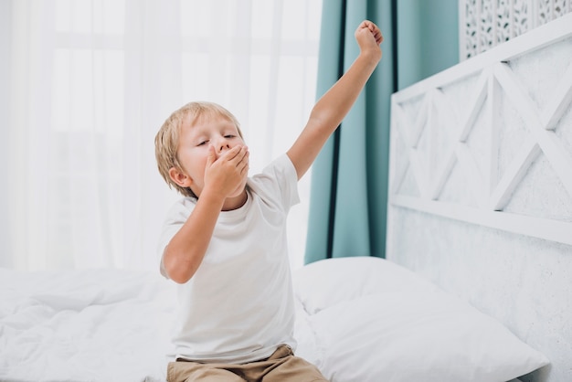 Free photo little boy yawning after waking up