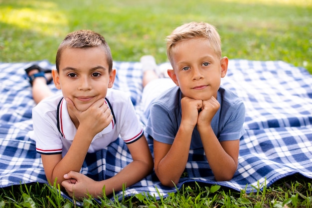 Ragazzini che posano su una coperta da picnic