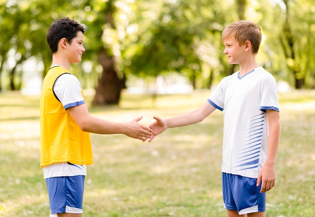 Little boys shaking hands before a football match